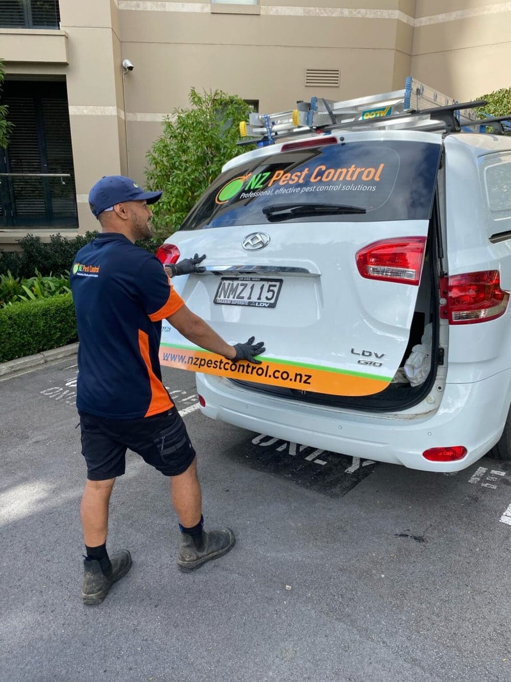 An NZ Pest Control technician at a branded work van